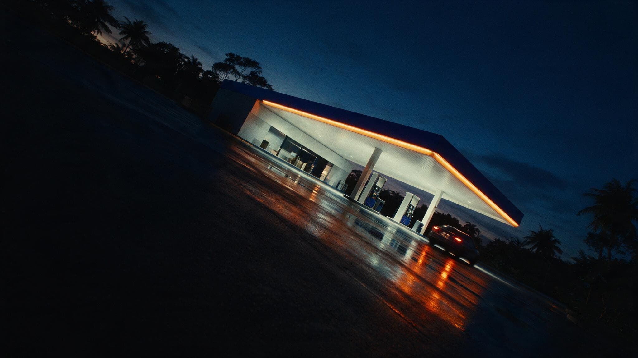 Fachada do Auto Posto Mammut iluminada ao anoitecer